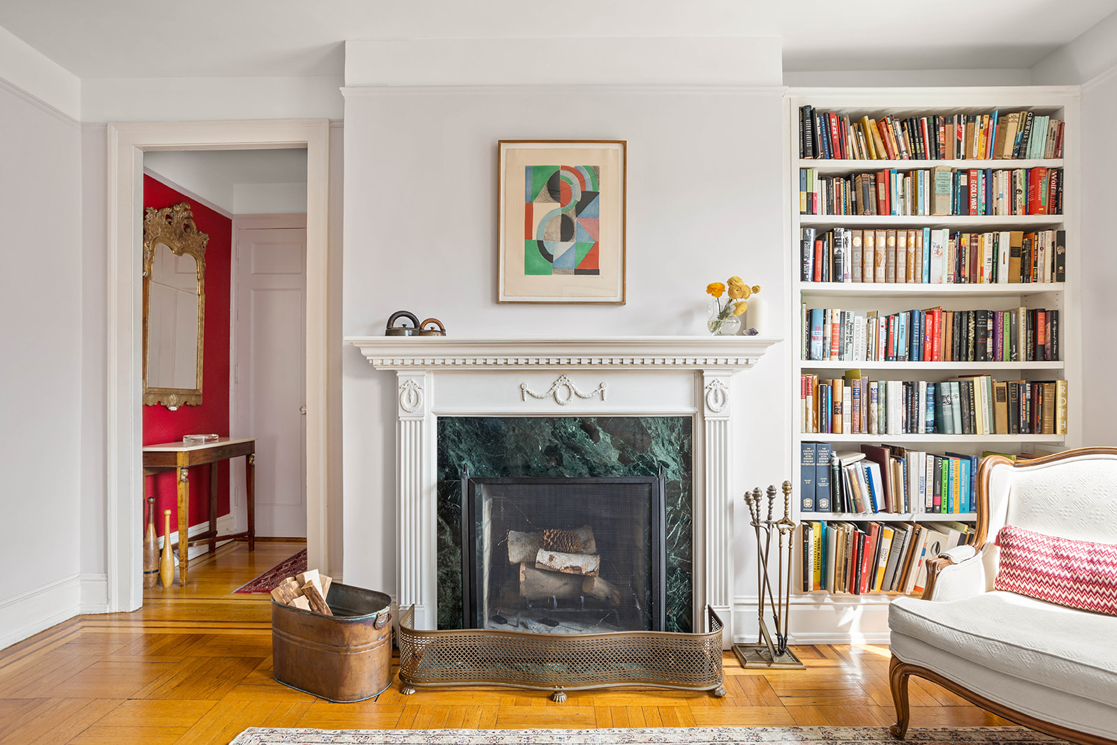 37-28 80th Street, Unit 32 Queens, NY 11372 - Photo 8 of 13 a living room with a bookshelf and a fireplace