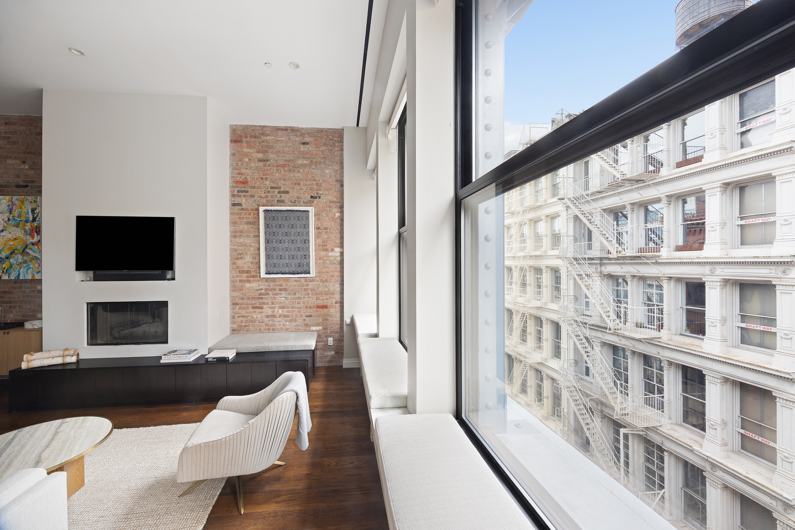 109 Greene Street, Unit 5A Manhattan, NY 10012 - Photo 6 of 18 a living room with fireplace furniture and a flat screen tv