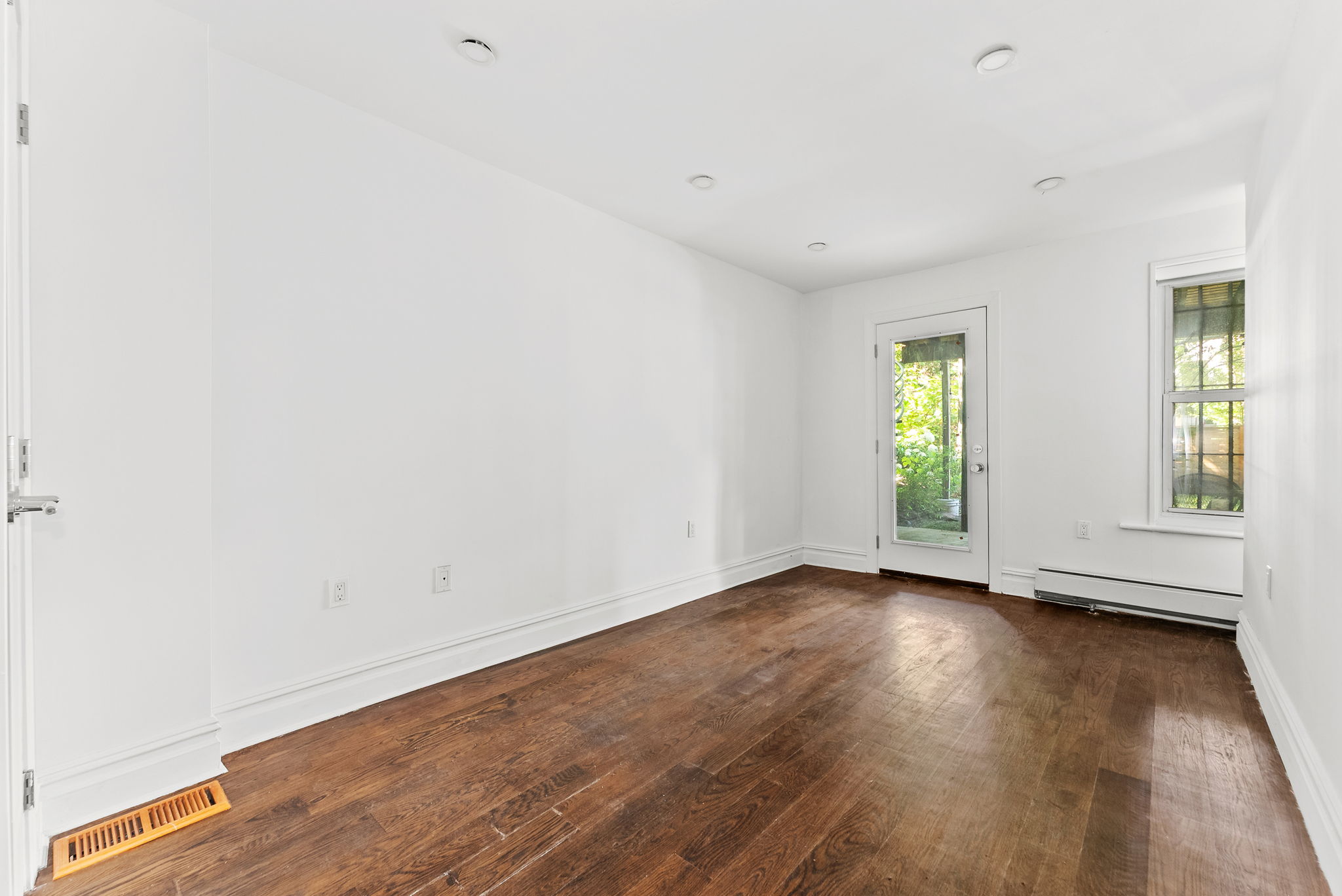 692 10th Street, Unit 1 Brooklyn, NY 11215 - Photo 6 of 12 an empty room with wooden floor and windows