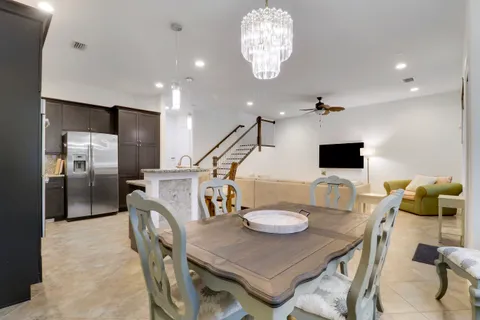 a kitchen with stainless steel appliances kitchen island granite countertop a dining table and chairs