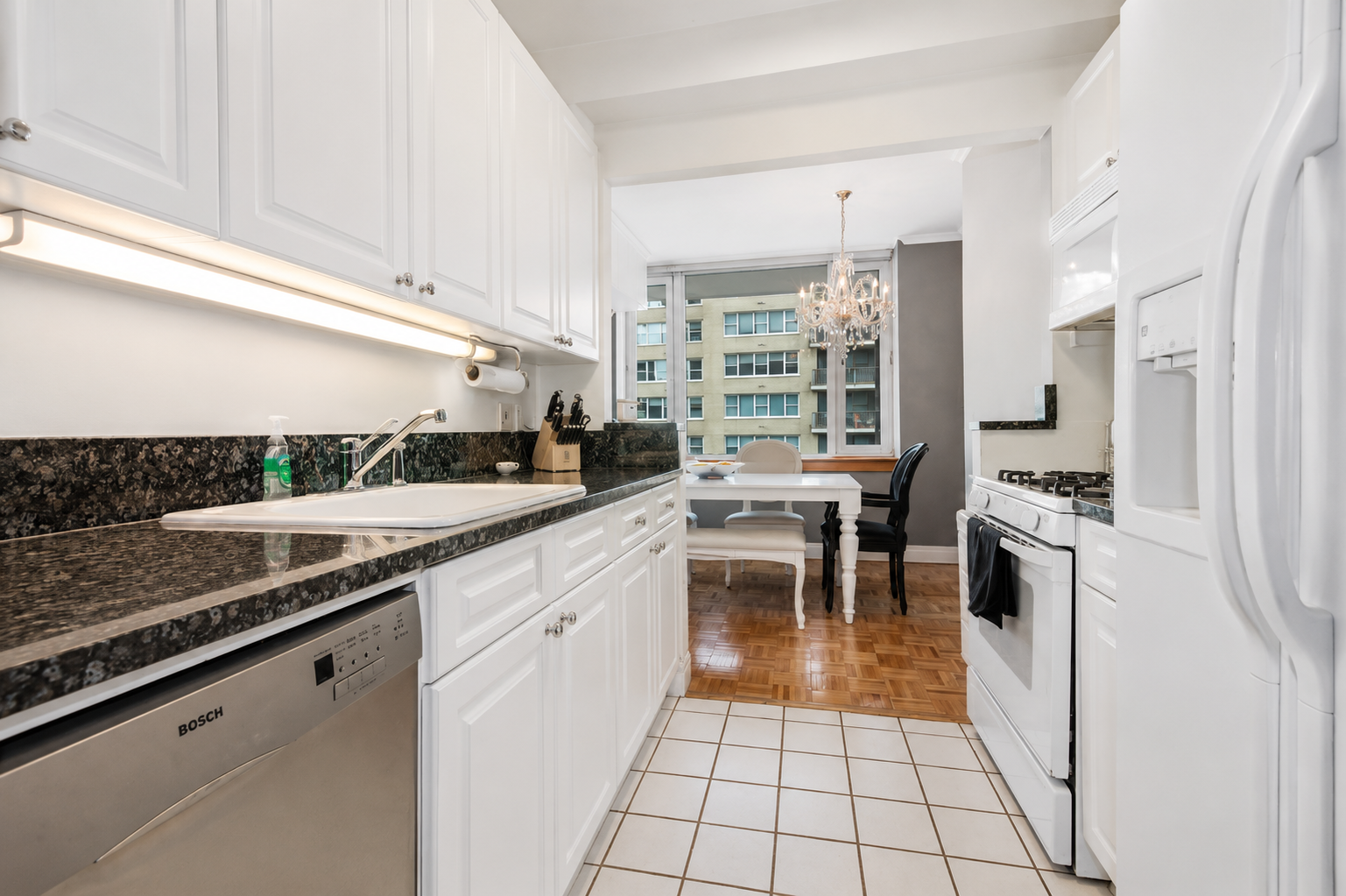 404 East 76th Street, Unit 6B Manhattan, NY 10021 - Photo 3 of 7 a kitchen with stainless steel appliances granite countertop a stove a sink and a refrigerator