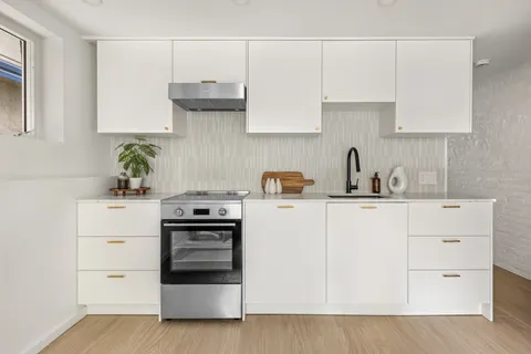a kitchen with white cabinets and white appliances