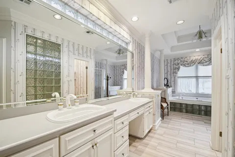 a spacious bathroom with a double vanity sink a mirror and a shower