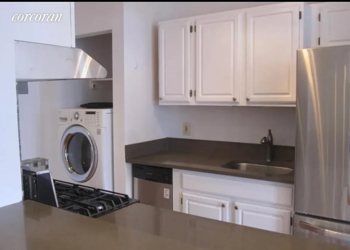 a kitchen with granite countertop a sink stove and cabinets