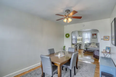 a view of a dining room with furniture and a chandelier fan