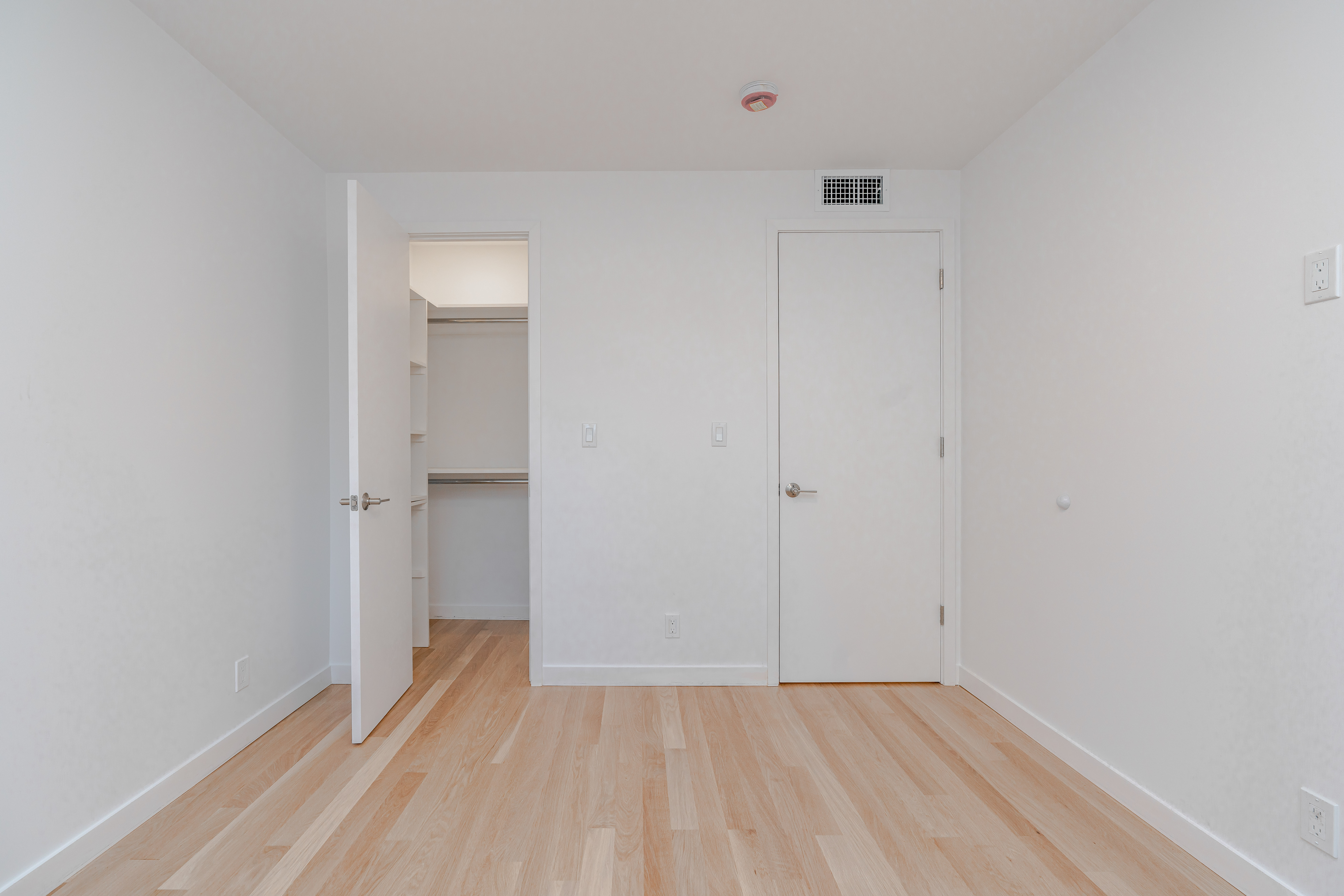 20-15 46th Street, Unit 2 Queens, NY 11105 - Photo 12 of 16 a view of an empty room with wooden floor and closet