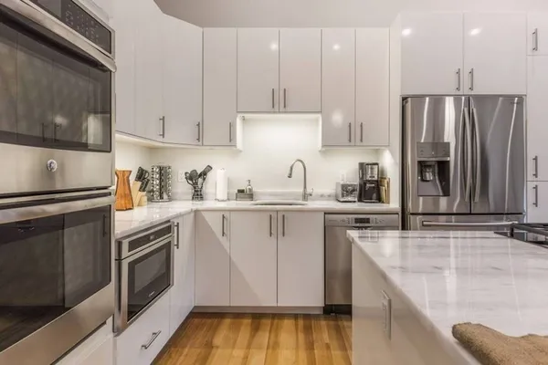 a kitchen with stainless steel appliances granite countertop a refrigerator sink and stove