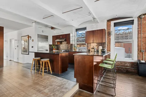 a living room with furniture a kitchen view and a window