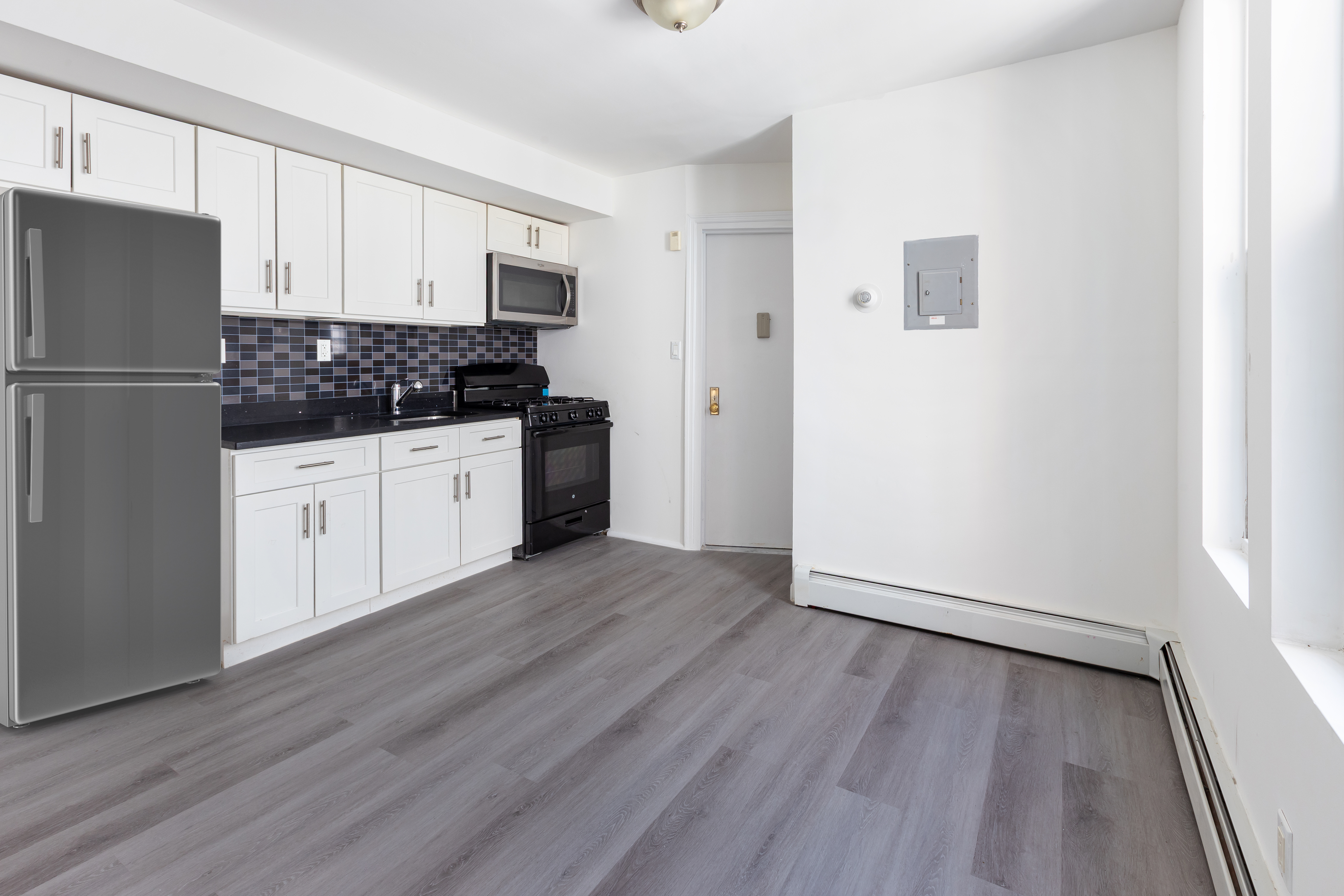 1030 Winthrop Street, Unit 2A Brooklyn, NY 11212 - Photo 2 of 10 a kitchen with granite countertop white cabinets and stainless steel appliances