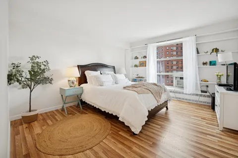 a bed room with a bed and a potted plant