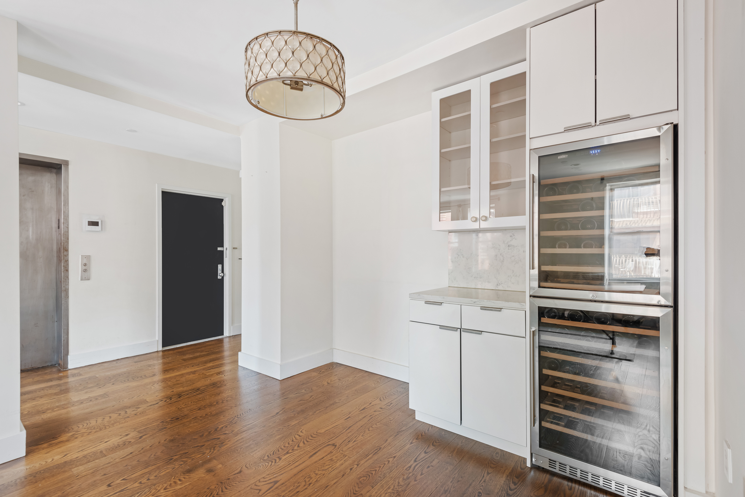 176 Mulberry Street, Unit 5 Manhattan, NY 10013 - Photo 7 of 12 a kitchen with granite countertop a refrigerator and cabinets