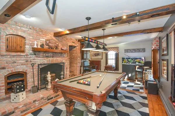 a living room with pool table and chairs