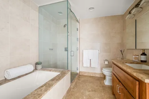 a spacious bathroom with a granite countertop sink a toilet and shower