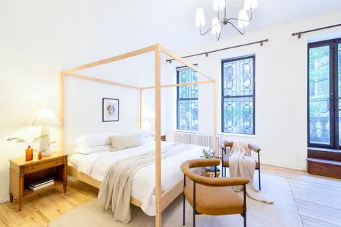 a bedroom with a bed and wooden floor