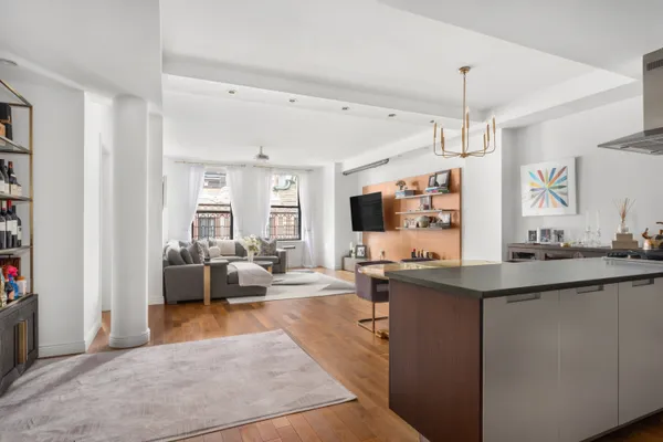 a living room with kitchen island furniture and a flat screen tv