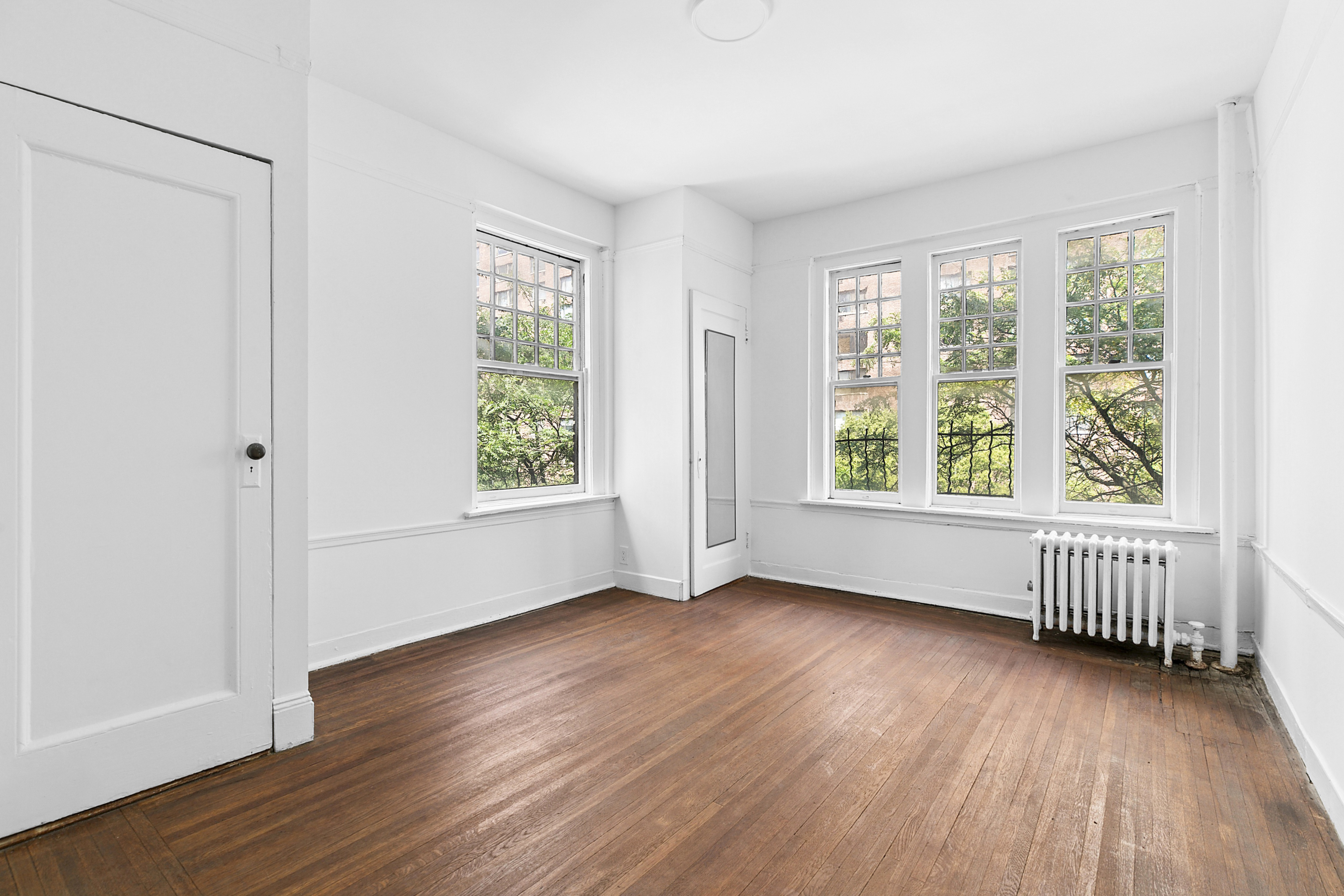 370 Central Park West, Unit 413 Manhattan, NY 10025 - Photo 6 of 19 an empty room with wooden floor and windows
