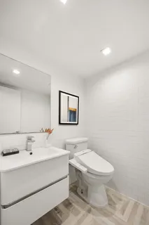 a bathroom with a sink mirror and toilet