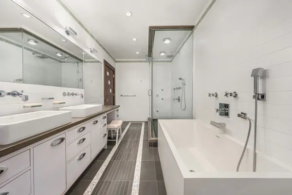 a spacious bathroom with a tub sink and mirror