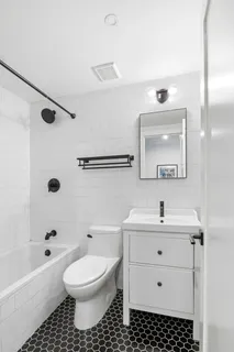 a bathroom with a sink toilet a mirror and shower