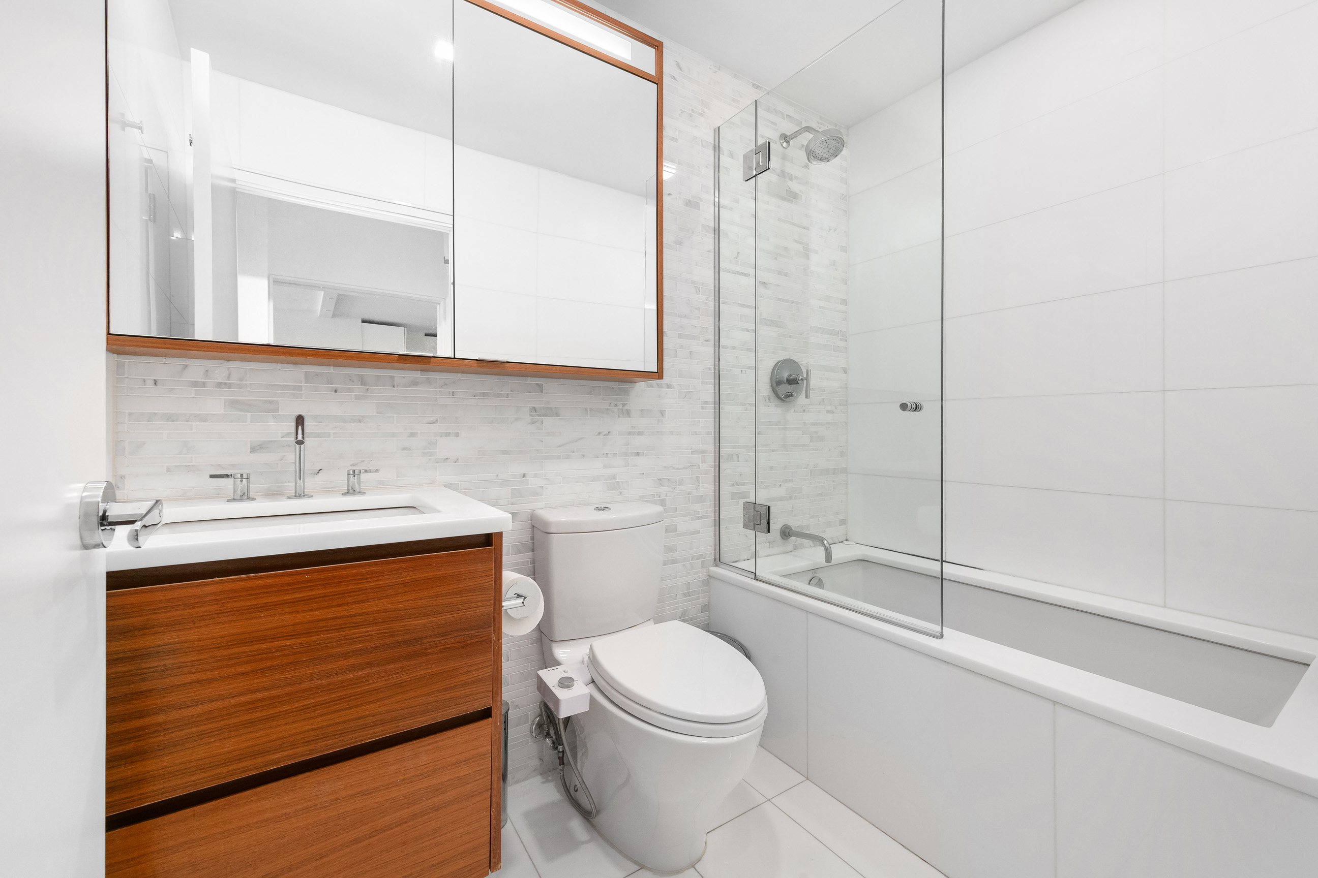 301 West 53rd Street, Unit 19F Manhattan, NY 10019 - Photo 6 of 7 a bathroom with a sink a toilet and shower