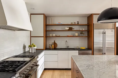a kitchen with granite countertop a sink a stove and wooden cabinets