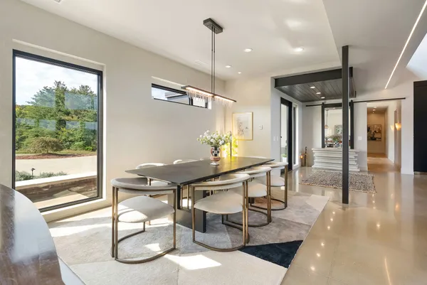 a living room with furniture a large window and kitchen view
