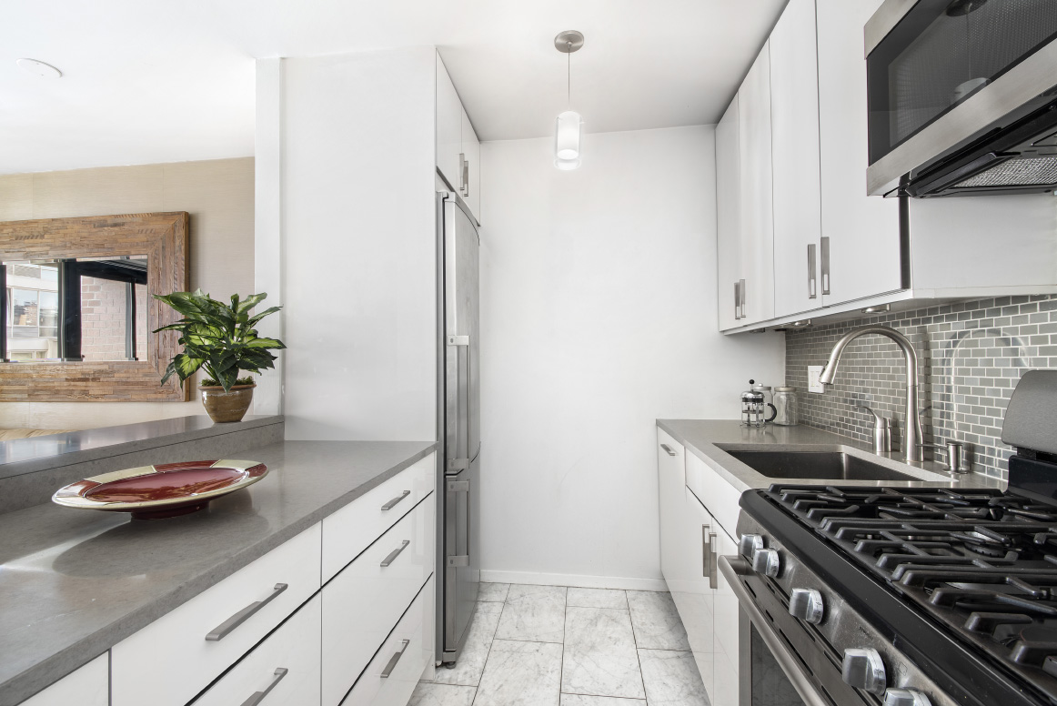 445 West 19th Street, Unit 6C Manhattan, NY 10011 - Photo 4 of 10 a kitchen with a sink stove and cabinets