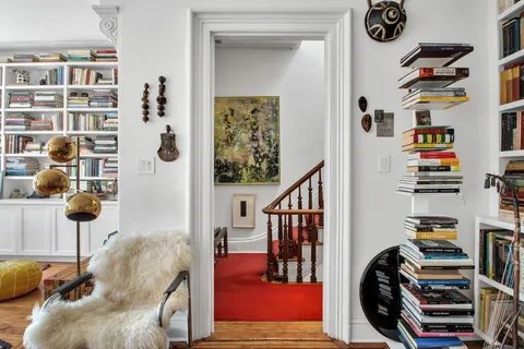a view of a bedroom with furniture and book shelf