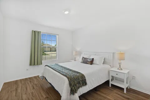 a bedroom with a bed and wooden floor
