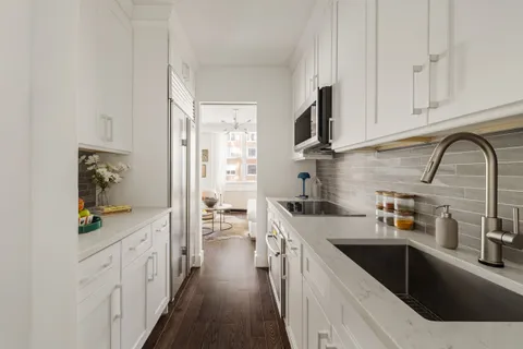 a kitchen with stainless steel appliances granite countertop a sink stove and cabinets