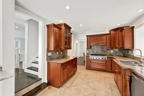a kitchen with stainless steel appliances granite countertop a sink stove and cabinets