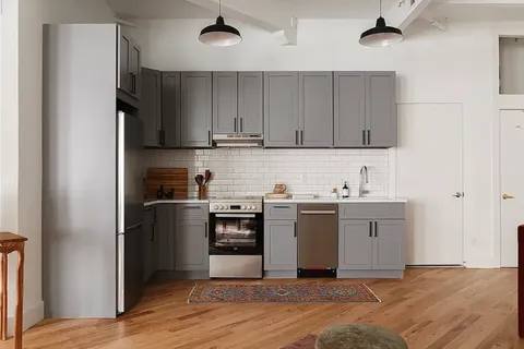 a kitchen with stainless steel appliances granite countertop a refrigerator and a sink