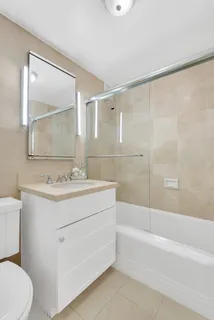 a bathroom with a sink mirror vanity and toilet