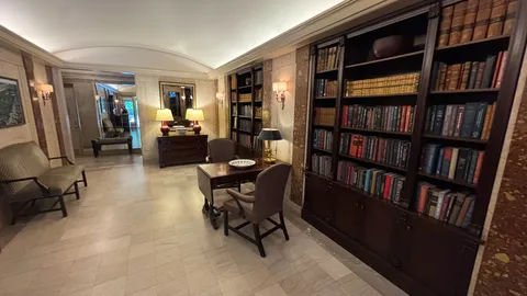 a living room with furniture a rug and a book shelf