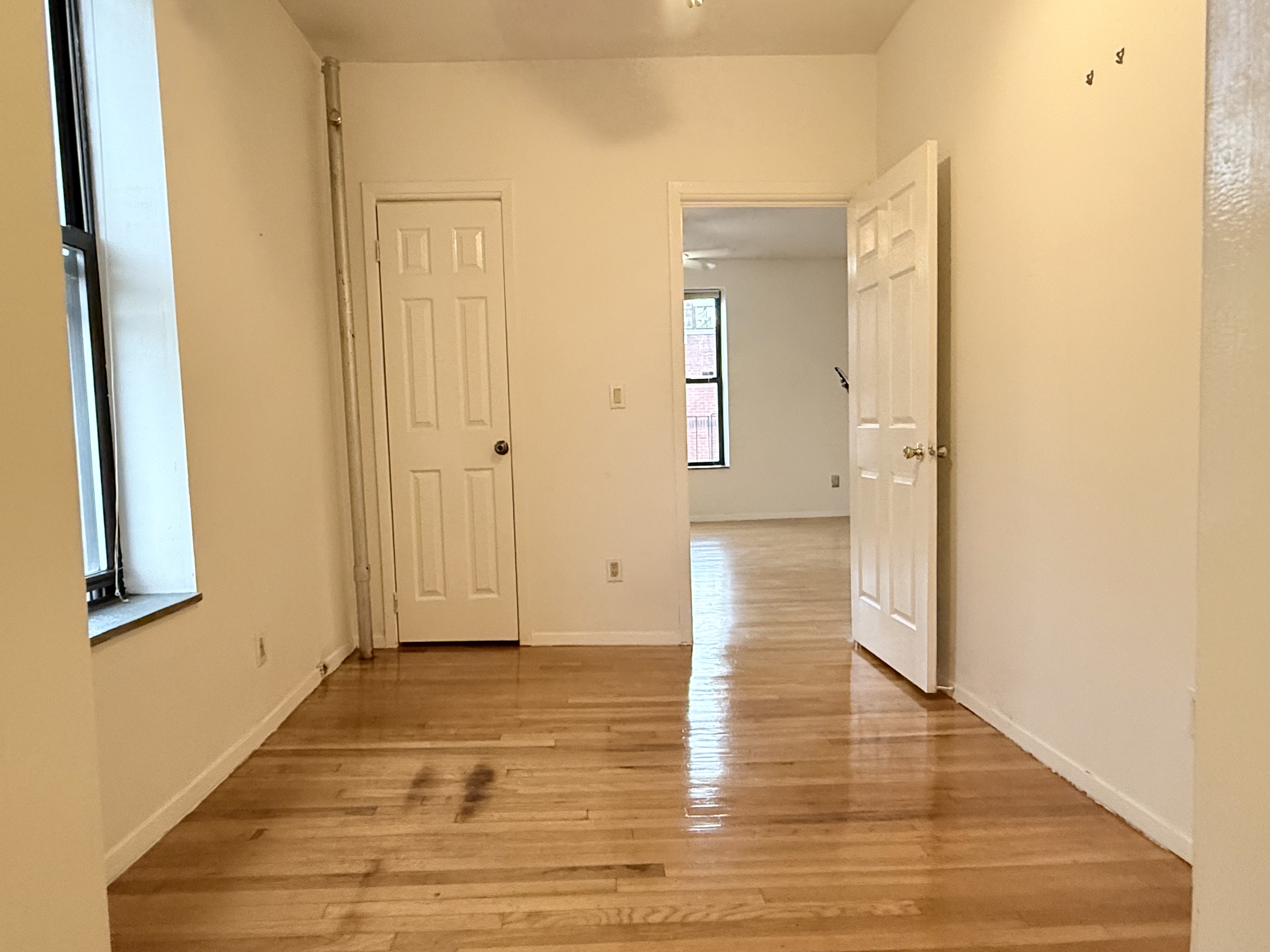 1672 Park Avenue, Unit 4A Manhattan, NY 10035 - Photo 11 of 11 a view of a hallway with wooden floor and a bathroom