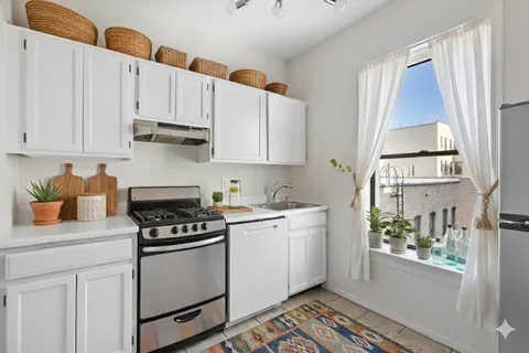 a kitchen with stainless steel appliances white cabinets and a stove top oven