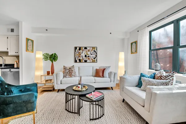 a living room with furniture large window and wooden floor