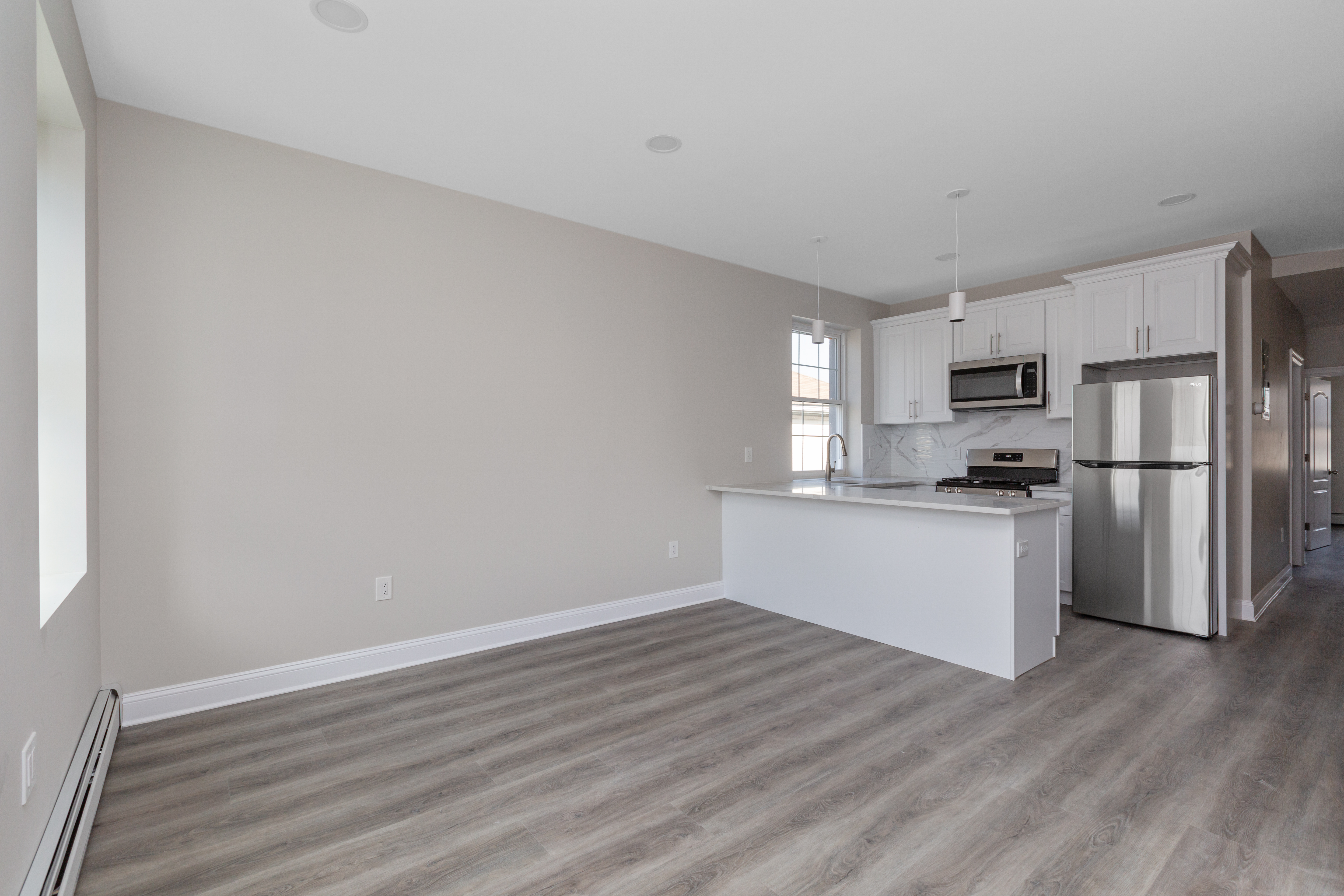 143-10 Shore Avenue Queens, NY 11435 - Photo 4 of 30 a kitchen with a refrigerator stove and white cabinets