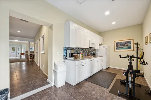 a living room with furniture a fireplace and large windows