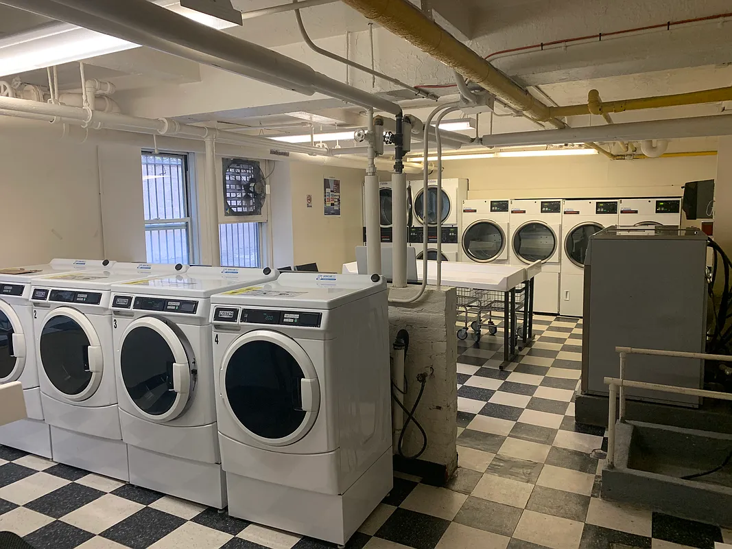433 West 34th Street, Unit 3E Manhattan, NY 10001 - Photo 5 of 10 a utility room with dryer washer and a view of living room