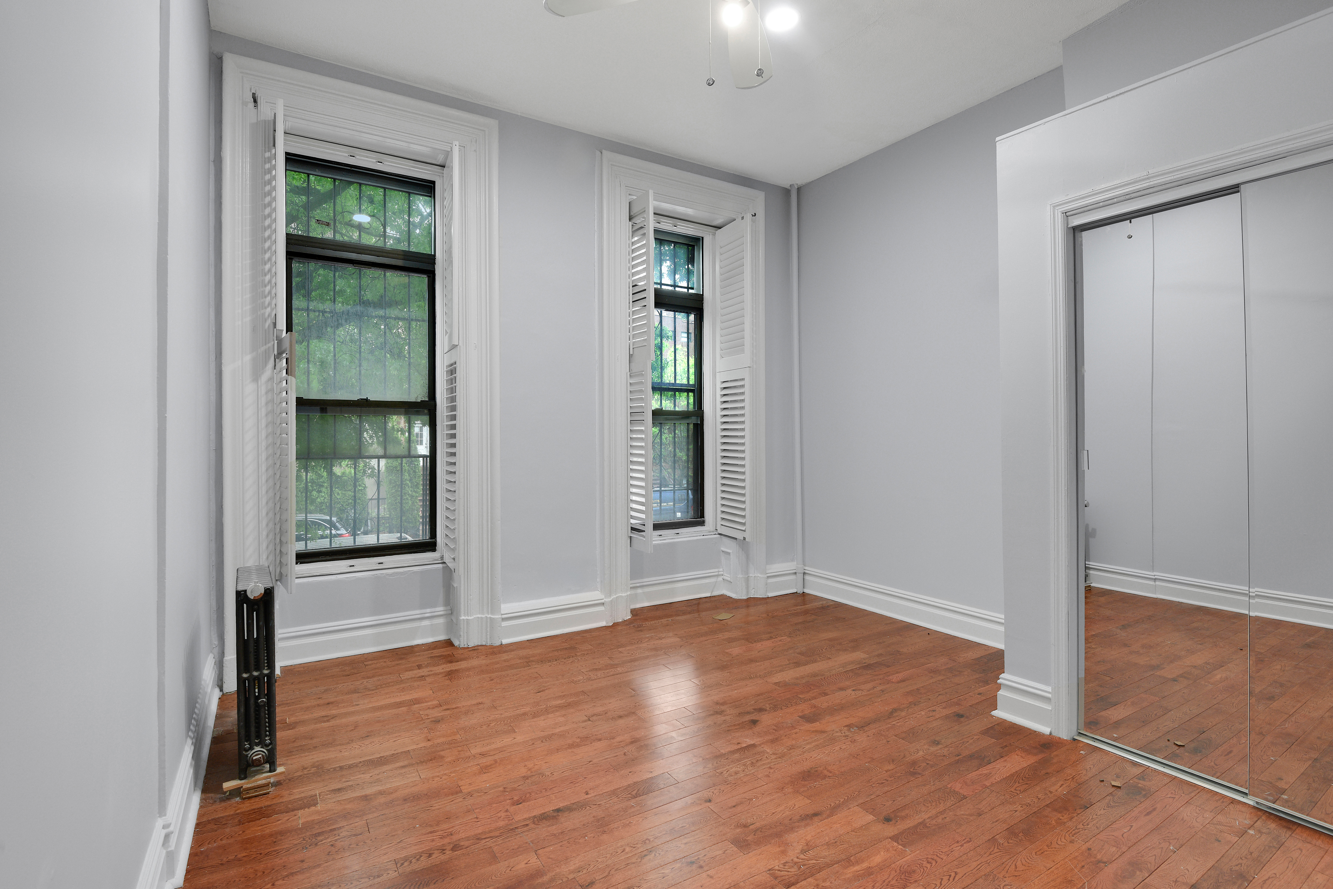 615 Willoughby Avenue, Unit 1 Brooklyn, NY 11206 - Photo 7 of 13 an empty room with wooden floor and windows