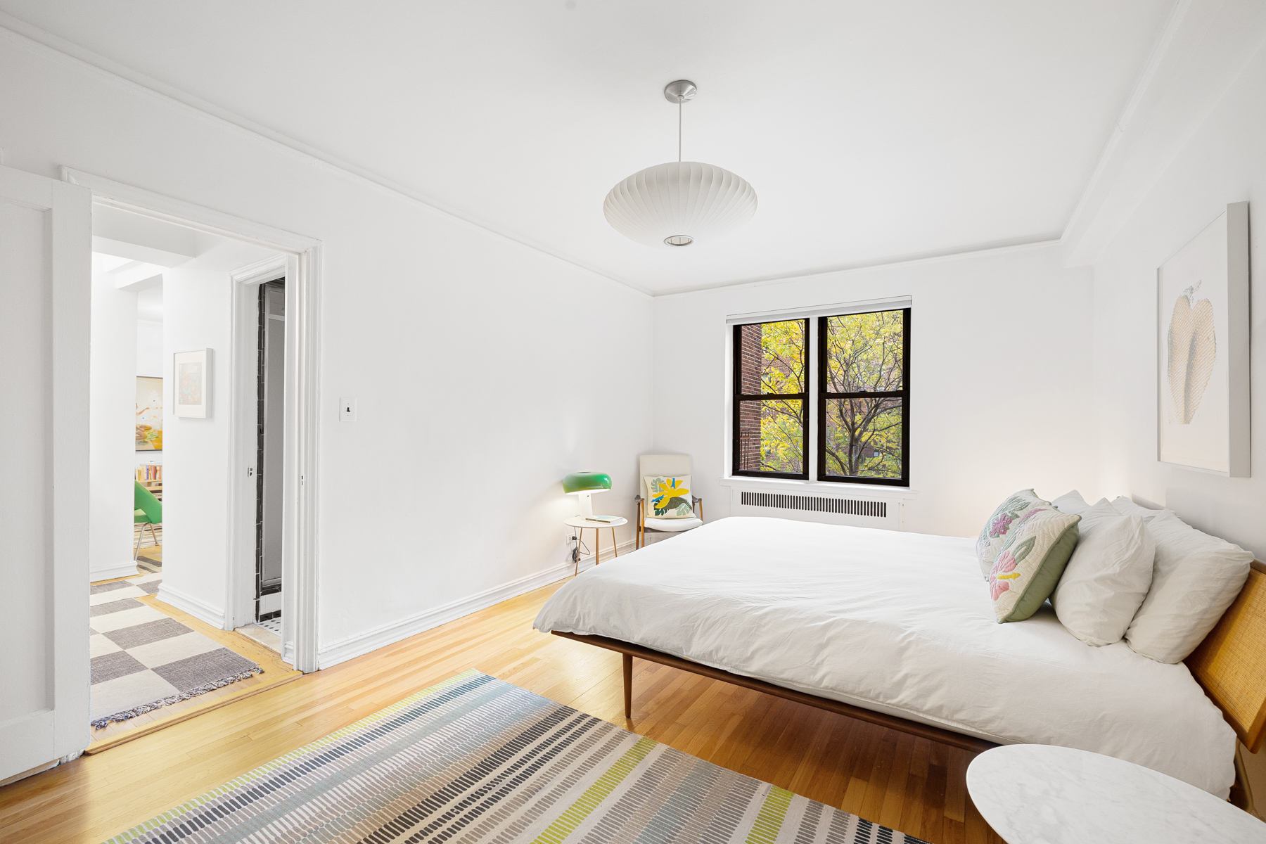 77-11 35th Avenue, Unit 3N Queens, NY 11372 - Photo 12 of 21 a bedroom with a bed and a window