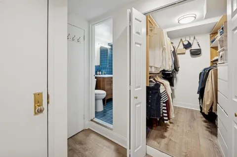 a view of walk in closet with clothes and shoes