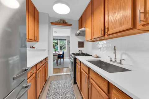 a kitchen with stainless steel appliances granite countertop a sink and a stove