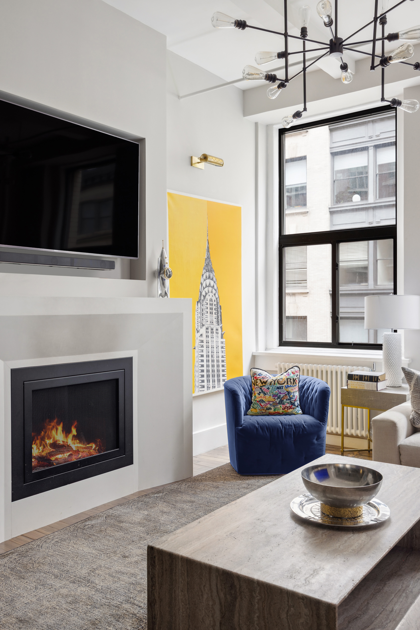 129 West 22nd Street, Unit 5A Manhattan, NY 10011 - Photo 4 of 13 a living room with furniture a flat screen tv and a fireplace