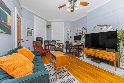 a living room with furniture a flat screen tv and kitchen view
