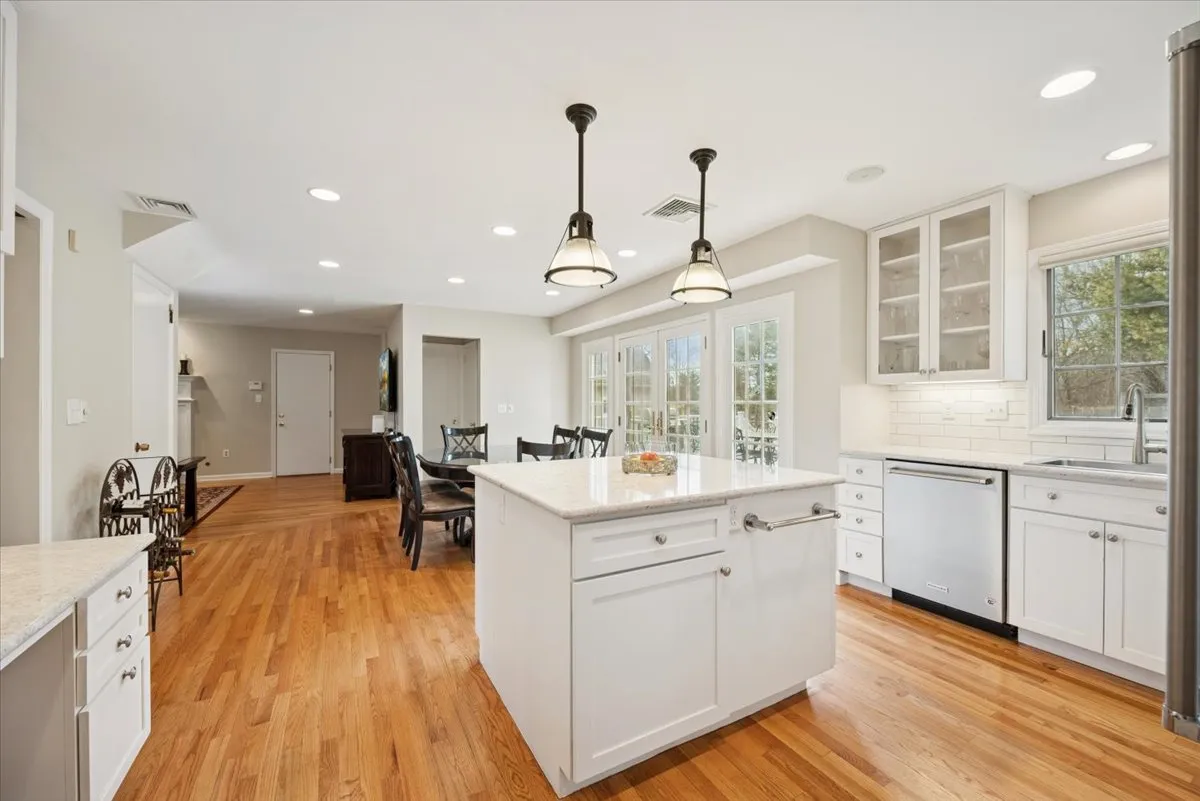 a kitchen with stainless steel appliances granite countertop a sink a stove and a wooden floors