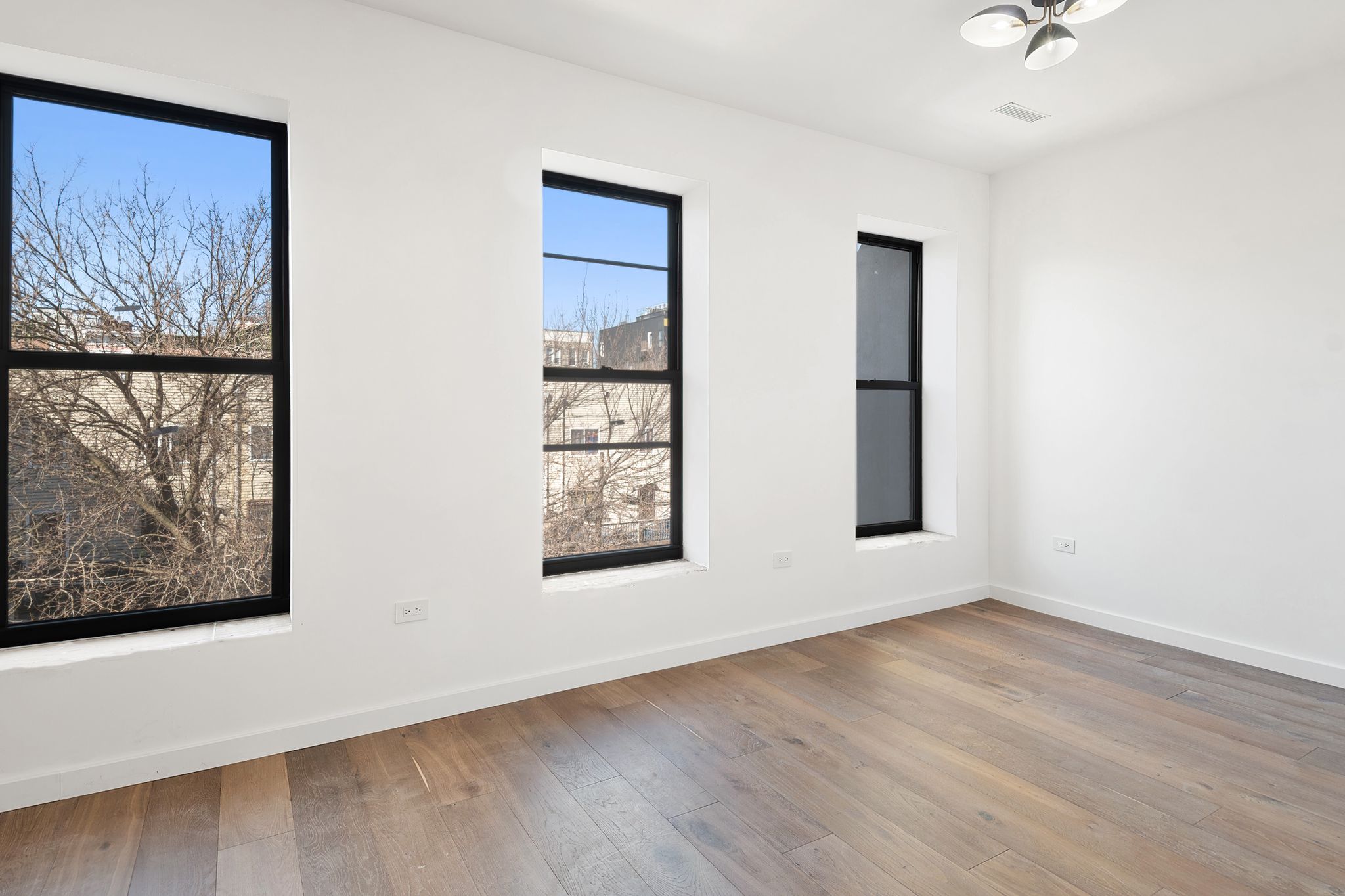 181 Kosciuszko Street Brooklyn, NY 11216 - Photo 14 of 20 a view of an empty room with wooden floor and a painting on the wall