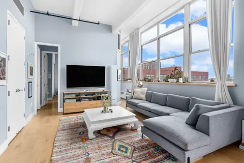 a living room with furniture a large window and a flat screen tv