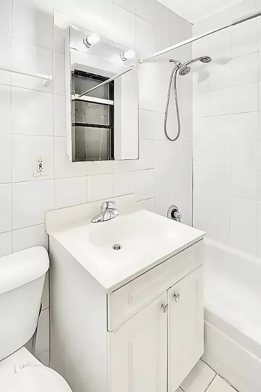 422 Amsterdam Avenue, Unit 2C Manhattan, NY 10024 - Photo 3 of 8 a bathroom with a sink toilet vanity and shower